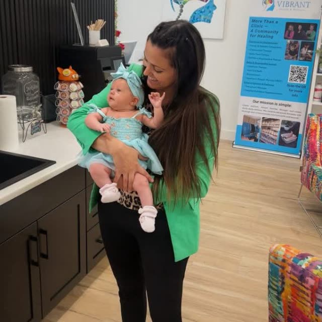 Holding a happy baby at Vibrant Health & Wellness